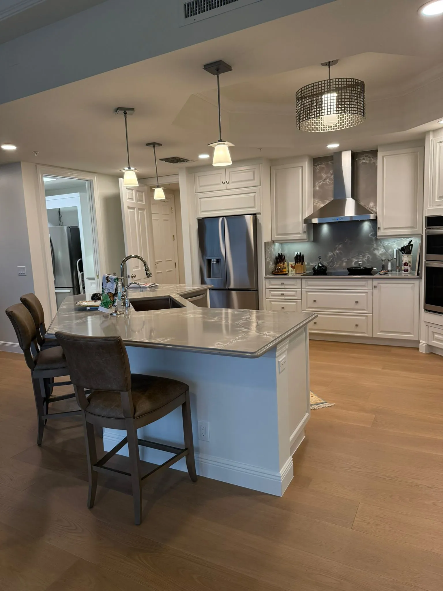 White kitchen with gray quartz island and seating