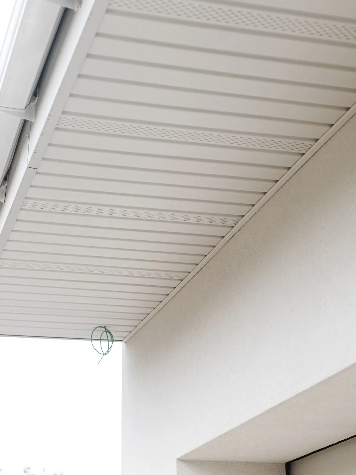 New vented soffit panels under a roof overhang