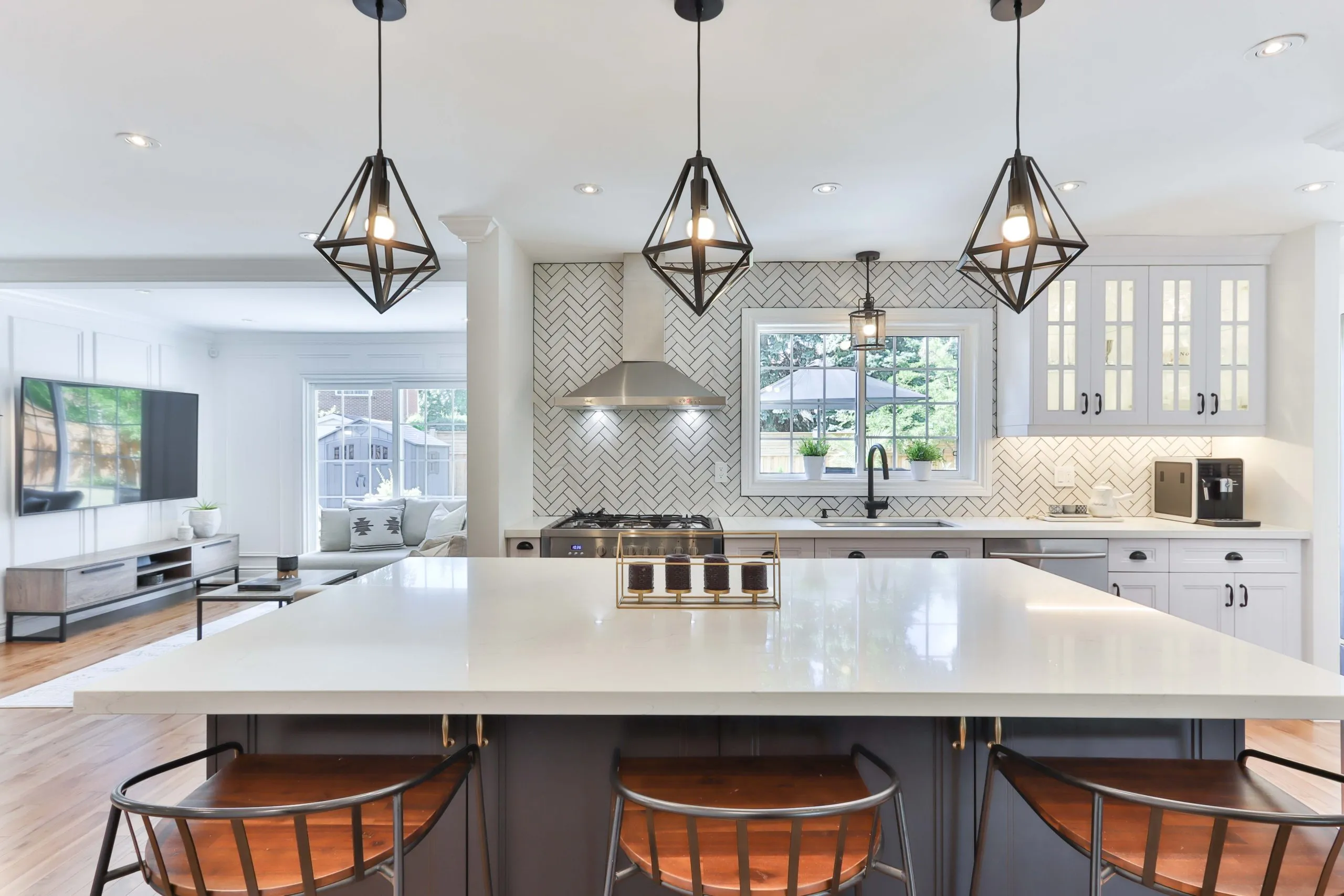 White kitchen with quartz island and geometric pendant lights