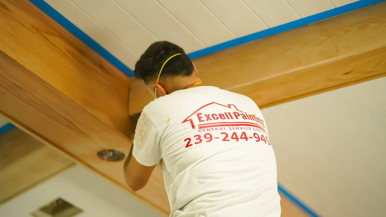 Excell painter preparing a wood ceiling beam