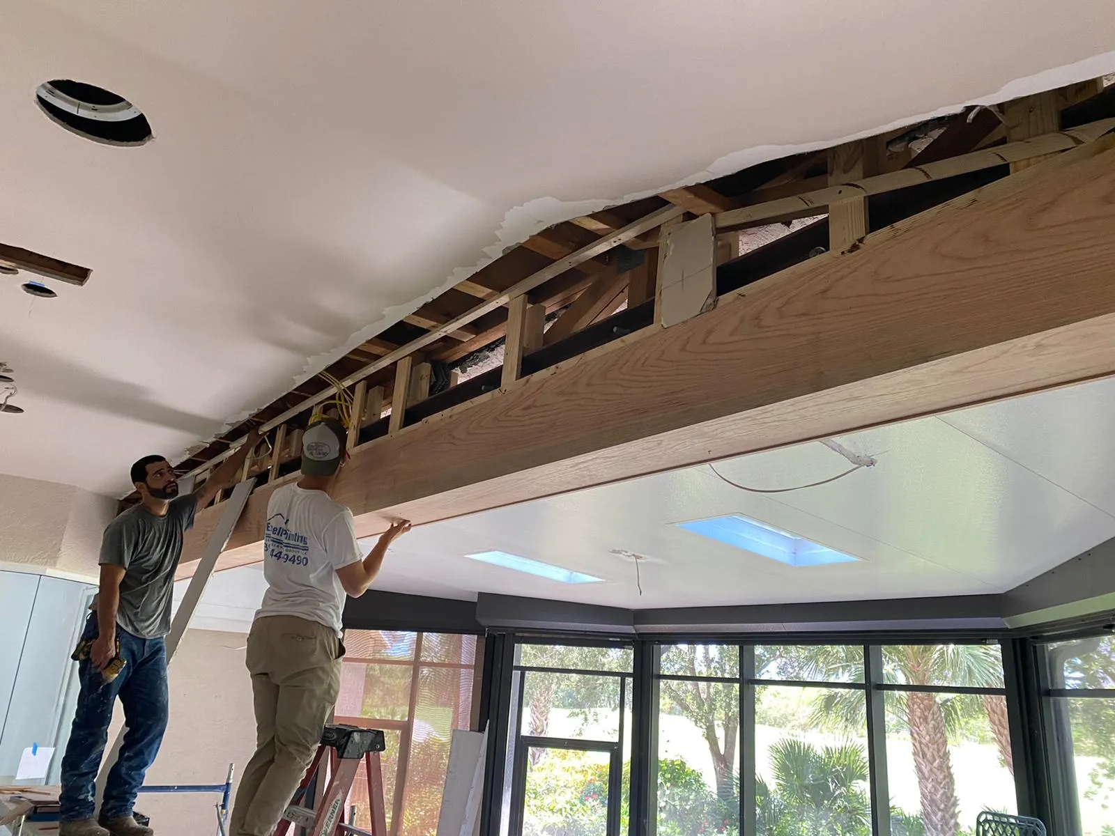 Crew installing a ceiling beam in a lanai