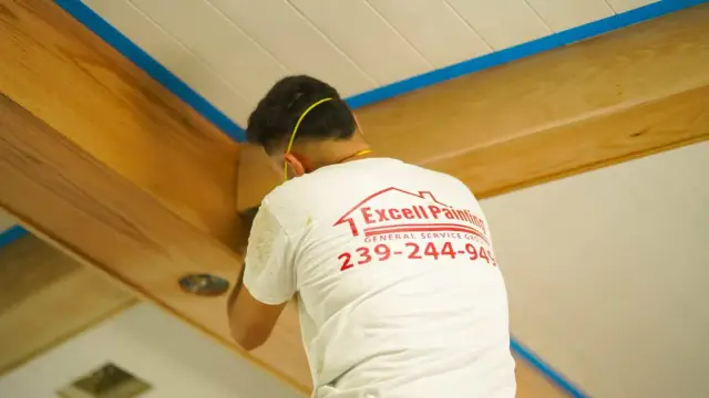Excell painter finishing a wood ceiling beam