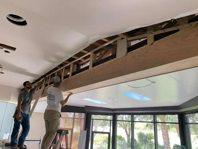 Excell crew repairing a ceiling with drywall